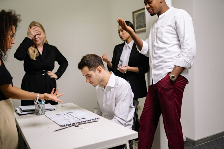 Des professionnels du secteur engagés dans une discussion tendue au bureau, mettant en évidence le conflit au travail.